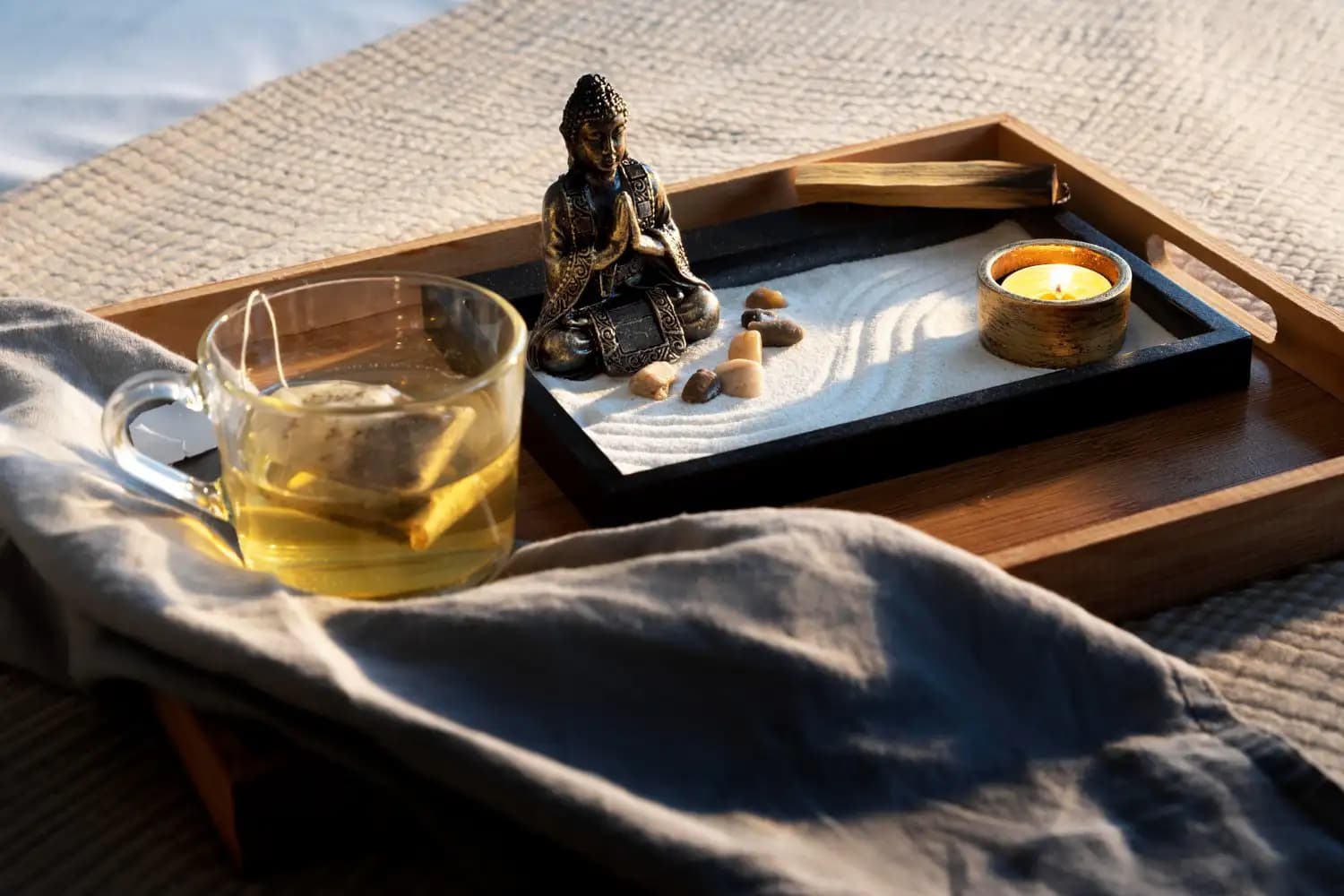 A quiet tea ceremony setting with a Buddha statue and sand garden, reflecting the calm of a Feng Shui consultation